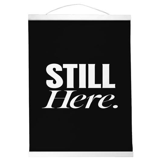 "Still Here." — Quorum Hanging Canvas, Sign Black type on pure white canvas with black hanger